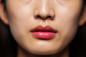 Obraz premium Shiny pink lips and nose ring glossy mouth