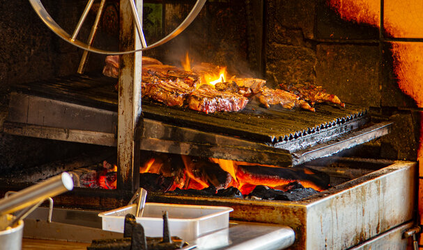 A rustic latin kitchen with steaks cooking on a wood fire