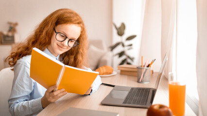 Learning And Education Concept. Portrait of young smiling red-haired girl wearing eyeglasses,...