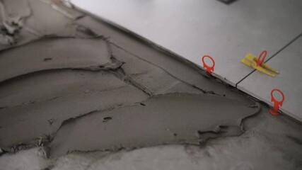 Worker spreading tile adhesive with flat spatula