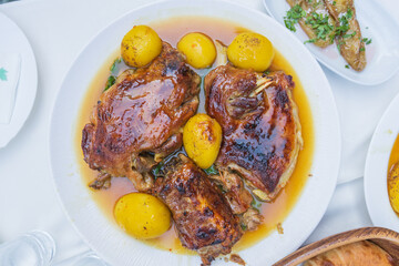 Delicious roasted lamb and golden potatoes in gravy served on a white plate, showcasing traditional Mediterranean cuisine and comfort food.