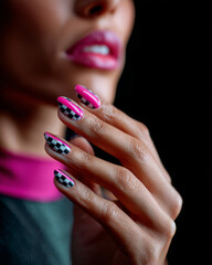Stylish checkerboard manicure on a woman with glossy lips and vivid nail colors