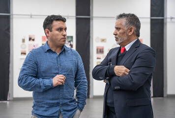 two businessmen looking at each other seriously