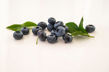 Blueberry berries with green leaf on white isolated background.