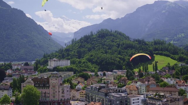Paragliders Soaring Above Interlaken, Switzerland with Alpine Mountains in the Background