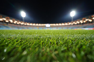 Fototapeta premium Close-up of Wet Football Field Grass at Night Stadium