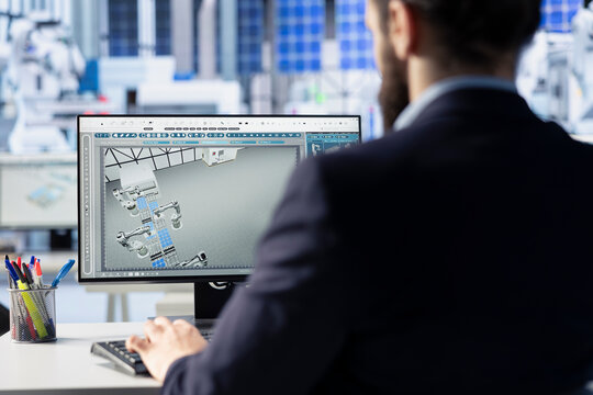 Photovoltaics factory expert creates CAD models and technical drawings for solar modules using computer. Worker uses PC to develop and optimize solar panel designs for efficiency and manufacturability