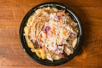 Macaroni and cheese topped with pulled pork and coleslaw