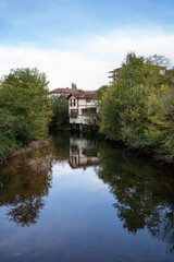 Fototapeta premium A scenic view of a traditional Basque house reflecting on the Nivelle river in France.