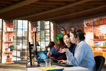 Naklejka premium Experienced call center manager guiding intern on how to use AI chatbot in office. Asian customer support workplace onboarding specialist teaching new worker to use artificial intelligence assistant