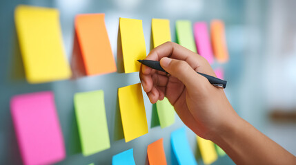 entrepreneur writing tips on sticky notes and placing on wall