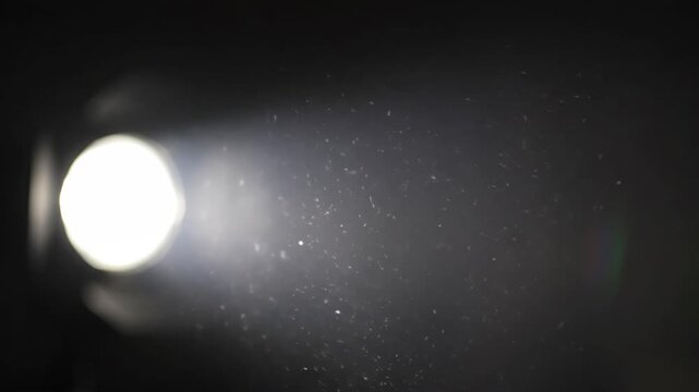 Video studio Fresnel lens spotlight on black background. Lights slowly turn on and off. Close up.
