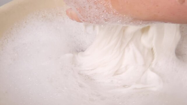 female Hands immersed in soapy water, gently scrubbing fabric clean, Nostalgic scene traditional laundry methods in modern times, Domestic chores