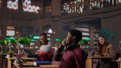 Rude man answering a phone call in the library and disturbing people, being very noisy. Students asking to keep quiet, losing focus and concentration while learning or reading. Camera B.