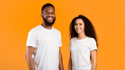 Multiethnic Couple Posing Wearing White T-Shirts Smiling To Camera Standing Over Yellow Studio Background. Diverse Friendship And Relationship. Happy Multiracial Young Family's Portrait. Panorama