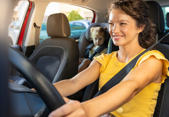 Mother driving while child is safely seated in car seat