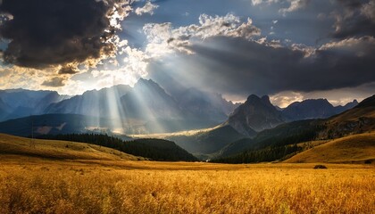 dramatic mountain landscape with sun rays breaking through stormy clouds and golden fields
