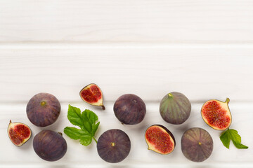 Fresh tasty fig fruits on wooden background, top view