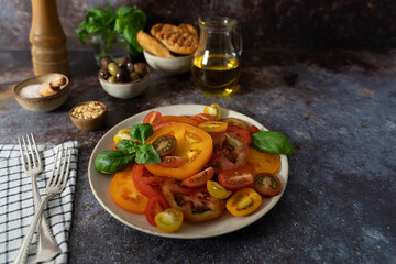 Close Up of Sliced Tomatoes with Basil, Olive Oil, Bread and Olives