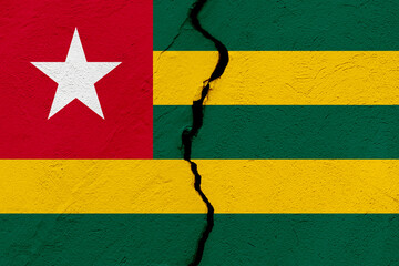 The flag of the Togolese Republic or Togo into a grunge cracked wall