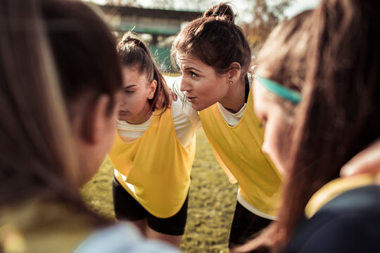 Teen soccer team huddling before match on outdoor field