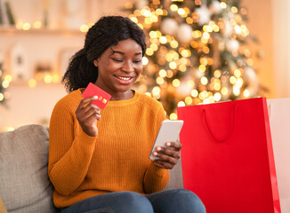 Modern fast online shopping, gifts for Christmas. Happy young african american female with...