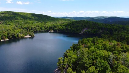 Obraz premium Panoramic view of a lake nestled amongst lush hills