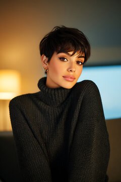model portrait pixie haircut turtleneck sweater indoor stylish woman sitting in cozy room