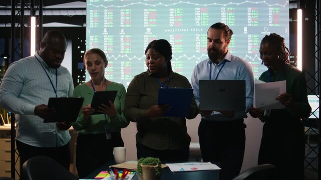 Portrait of diverse business colleagues reviewing monthly insights and performance indicators within the company. Employees conducting evaluations and sharing ideas for goal setting. Camera A.