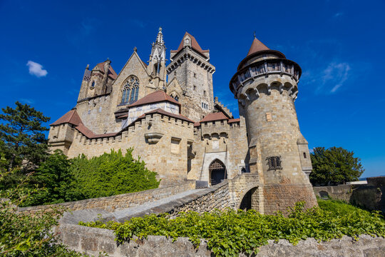 Castle in Europe. Medieval citadel made of stone bricks with towers and bridge. Rocky walls of an old historical castle with towers and bridge on a sunny summer day, European landmark and history