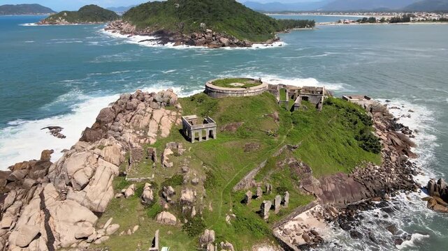 Aerial drone scene of the ruins of an ancient, abandoned, isolated fortress on a desert island. Fortaleza de Nossa Senhora da Concei&ccedil;&atilde;o Ara&ccedil;atuba in Praia de Naufragados Florian&oacute;polis Santa Catarina