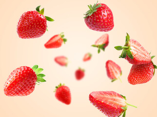 Yummy fresh strawberries swirling in air against beige background