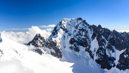 Snow-covered mountain peak under clear blue sky, bright daylight