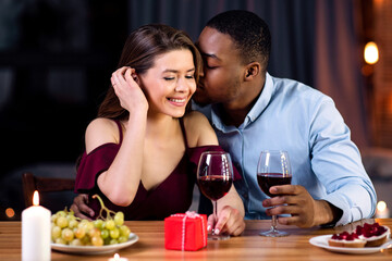 Portrait Of Affectionate Interracial Couple Having Romantic Date In Restaurant, Celebrating Valentine's Day Together, Passionate Black Man Whispering Love Words To His Girfriend's Ear, Free Space