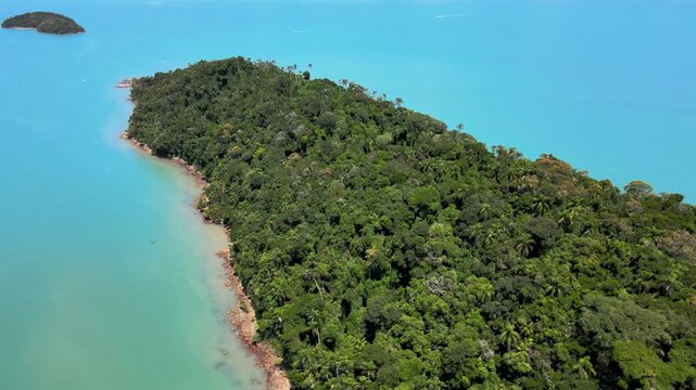 Orbital panoramic drone aerial scene of isolated tropical Ratones Island filled with Atlantic Forest trees and rocks with turquoise and cyan sea near Daniela Beach in Florian&oacute;polis, Brazil
