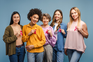 Interracial women showing pink ribbons for breast cancer awareness posing together