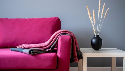 Cozy living room interior with fuchsia couch throw blanket and decorative vase showcasing modern home decor and comfortable relaxation space