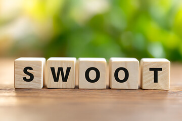 Creative Wooden Blocks Spell the Word Swoot is Displayed on a Rustic Wooden Surface Surrounded by Greenery