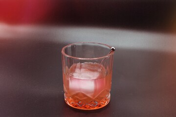 This photo features a perfectly crafted cocktail served in a lowball or rocks glass with a...