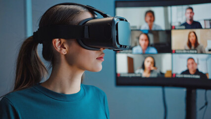 Virtual Meeting Experience: A woman immersed in a virtual reality headset experiences a collaborative meeting environment, seamlessly interacting with remote colleagues on the screen.
