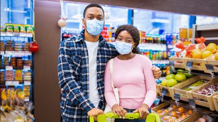 Shopping during covid quarantine. Portrait of young black couple wearing protective mask, buying...