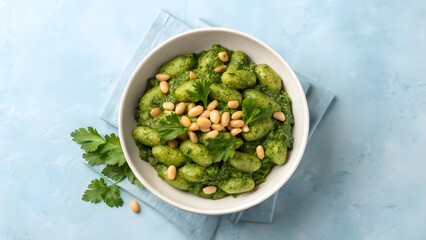 Delicious Bowl Of Green Gnocchi Pasta With Pesto Sauce Garnished With Pine Nuts And Fresh Parsley On Blue Background Flatlay Scene

