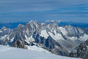 Fototapeta premium View of Aiguille du Midi summit from ascent route Gouter to Montblanc. Chamonix valley landscape of a prominent rocky towering mountain peak Aiguille du Midi in French Alps. Chamonix-Montblanc area