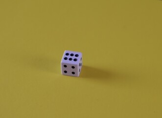Una toma de cerca  de uno o varios dados blancos para juego en un fondo amarillo