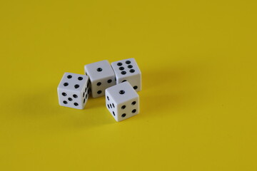 Una toma de cerca  de uno o varios dados blancos para juego en un fondo amarillo