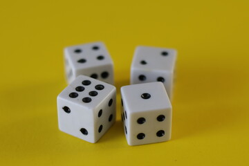 Una toma de cerca  de uno o varios dados blancos para juego en un fondo amarillo