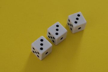 Una toma de cerca  de uno o varios dados blancos para juego en un fondo amarillo