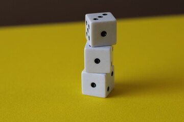 Una toma de cerca  de uno o varios dados blancos para juego en un fondo amarillo