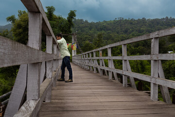 Man standing on wooden bridge in himachal forest