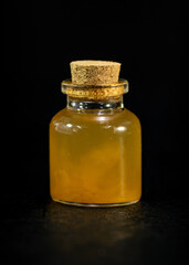 small bottle apple cider vinegar potion bottle close up black background